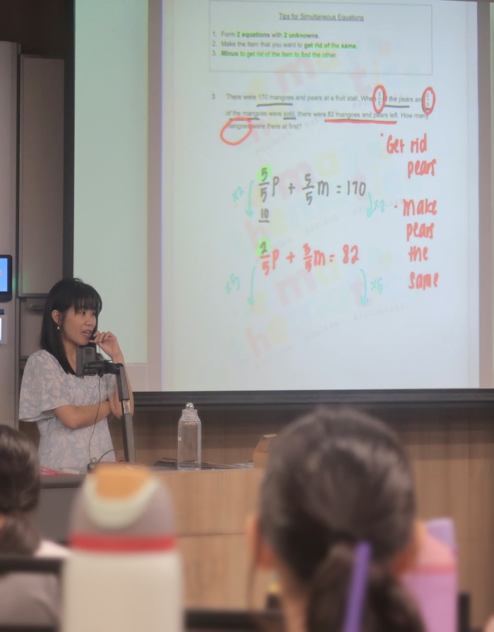 May teaching a PSLE Math lesson in a lecture hall
